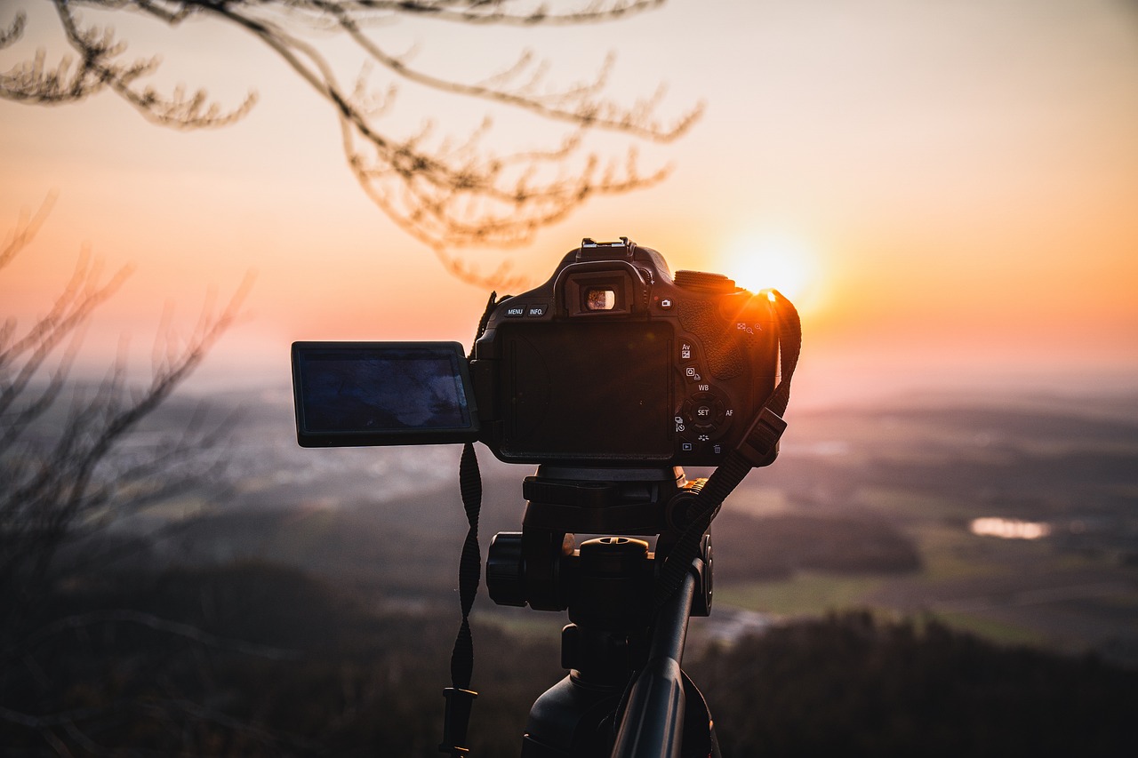 aparat fotograficzny na tle zachodzącego słońca